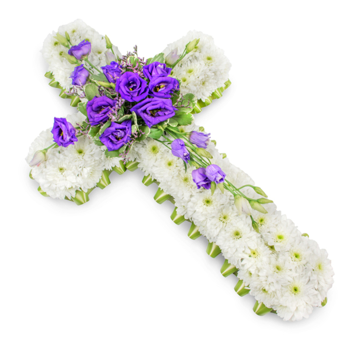 A solemn yet graceful cross-shaped floral tribute is shown against a clear white studio background, the neutral setting highlighting each carefully chosen bloom. The cross is fully carpeted in small white spray chrysanthemums, their petals layered closely to produce a thick, pillowed texture. The flowers are so densely arranged that the surface reads as one continuous field of soft white, interrupted only by their delicate, light green centres. This quietly luminous base calls to mind still, misty mornings over Finsbury's tree-lined streets. Finishing the outline of the cross is a tidy band of lime-green ribbon, running uninterrupted along the outer edge of both arms and the full length of the vertical stem. The ribbon frames the design, offering a fresh and contemporary nod to nature amid the traditional Christian symbolism. At the meeting point of the cross's arms, a vivid focal cluster of deep royal purple lisianthus is arranged with deliberate care. Each lisianthus bloom, with its softly ruffled petals, opens into whorls of intense purple, adding depth and emotional weight to the piece. Fine, variegated foliage and small filler flowers weave between the lisianthus, introducing gentle texture and a subtle transition between the rich purples and the serene white chrysanthemums. From this centre, several lisianthus stems extend diagonally down the lower-right arm, creating a light cascade of blossoms and buds that give a sense of motion, almost like a gentle stream of colour flowing downwards. Soft, diffused lighting casts a faint halo of shadow beneath the cross, giving it dimension against the otherwise pristine background. This floral cross, the kind of thoughtful design you might request from Finsbury Flowers for a local church or crematorium service, offers a tender expression of condolence, faith, and cherished remembrance.