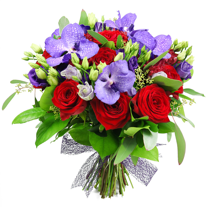 On a white studio backdrop, this hand-tied bouquet makes a bold statement of romance and refined luxury. The arrangement is a full, rounded sphere of color: deep red roses anchoring the center, their velvety petals curling into tight but blooming spirals, while purple Vanda orchids splay outward with their broad, satin-like petals speckled in darker lavender. Interlaced among the focal blooms are clusters of lisianthus in soft purples, some buds still shy, others unfurling to reveal pale lilac interiors and silvery touches that soften the mood. A lush tapestry of green leaves-broad, glossy blades and slender, almost feathery sprigs-frames the bouquet, creating depth and a sense of natural abundance. Small green buds dot the stems, signaling freshness, while wisps of pale green filler add delicate texture throughout. The stems are neatly gathered and secured at the base with a decorative dark mesh ribbon that forms a neat, contemporary bow, lending architectural elegance to the design. This opulent arrangement is ideal for anniversaries, a grand Valentine's gesture, or as a statement gift in a stylish setting from a dining room in Clerkenwell to a boutique hotel lobby near Islington. It suggests luxury and passion while remaining versatile enough to suit celebratory tables, events, or thoughtful thanks. Available through Finsbury Flowers for delivery across Finsbury and the surrounding districts, with same-day delivery offered to homes and businesses across central London.