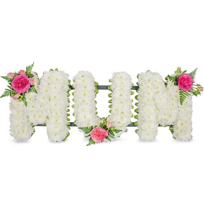 A touching floral arrangement in the shape of the word MOM dominates the centre of the image, placed against an uncluttered white background that allows all the fine details to be appreciated. Each letter is formed on a solid frame, edged in dark green ribbon that gives a neat, tailored finish often favoured by Finsbury Flowers for funeral lettering. Over this structure, a dense mat of white spray chrysanthemums has been carefully laid by hand. The small, rounded blooms are packed closely together, their petals overlapping slightly to form a continuous, pillowy surface. Their bright white colour imbues the tribute with a sense of calm and sincerity, evoking the quiet of early morning around Finsbury's hidden gardens and churchyards. The texture is soft and inviting, suggesting comfort and a gentle resting place for sentiments that can be hard to express. To bring warmth and individuality to the design, three floral accents of pink roses and greenery are integrated into the lettering. The first sits on the upper left arm of the initial M: a vibrant fuchsia rose in full bloom, surrounded by smaller blush pink spray roses and a few tender buds that hint at new life and cherished memories. Delicate fern fronds spread lightly around them, their fine, feathery leaves providing a natural, airy contrast to the more compact chrysanthemums. A second cluster appears low down where the O curves towards the final M, helping visually tie the middle and right of the tribute together. A third cluster crowns the upper right corner of the last M, repeating the rich fuchsia and soft pink tones, drawing the eye gently along the length of the word. This MOM arrangement is the kind of classic, comforting tribute that might be placed at a funeral service in Finsbury, Clerkenwell, or Islington, or carried in a hearse floral display. It speaks of love, gratitude, and a dignified farewell, its balanced design and calm colour palette offering solace to family and friends gathered to remember.
