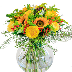 Bathed in the soft light that filters through Finsbury's leafy lanes, this floral arrangement is a tribute to joyful togetherness. The commanding sunflowers at its heart, their faces aglow in gold, stretch outward as if welcoming the day along Pentonville Road. Twisted spirals of yellow garden roses open luxuriously around them, their plushness contrasted by clusters of sparkling red Hypericum berries-tiny bursts of delight nestled amongst lively greens. Delicate sprigs of golden filler and feathery ferns spill over the edges, giving the bouquet a sense of light movement and echoing the wild corners of Finsbury's green spaces. All are anchored in a clear, rounded vase reminiscent of the modern architecture that dots City Road-showcasing the stems and the clarity of water below. The subtle scent is fresh and lively, conjuring memories of sunlit strolls through local parks or joyful afternoons spent in conversation. This visually rich composition, perfect for gracing a table on Amwell Street or sending to loved ones in Clerkenwell, is a celebration of happiness and community spirit. Every detail conveys the care and expertise of Finsbury's local florists, ensuring that each bouquet delivered is a piece of the neighbourhood brought to life.