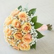 Radiating quiet luxury, this bouquet is styled with the thoughtful artistry emblematic of Finsbury's finest floral designers. Closely nestled together, a dozen peach and apricot-toned roses unfurl delicately, their petals shifting from a light, coral blush to a golden apricot center. Wisps of baby's breath (gypsophila) delicately interweave, lending the composition a sense of lightness and celebratory lace. Encircling the blooms, lush, glossy green leaves recall the verdancy of Finsbury's hidden gardens, supporting the roses' enchanting warmth. The stems are hand-finished with a peach-hued satin ribbon, meticulously adorned with tiny white pearls for a tactile accent, providing a subtle shimmer in natural city light. Set upon a finely textured, light-toned fabric, the bouquet is a vision of tender romance and contemporary elegance-ideally suited for weddings, anniversaries, or life's most treasured occasions celebrated in Finsbury's distinguished venues.