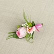 Set against a tactile, light beige linen backdrop-much like the tablecloths of beloved Finsbury cafés-this graceful boutonniere is a perfect expression of local craftsmanship and romantic intent. The focal point is a pale pink rose, its petals curled inward, glowing with the freshness and promise found in early hours at Spa Fields. An elegant, slightly ruffled alstroemeria in delicate peach and gold shades rests nearby, its intricate central markings reminiscent of Finsbury's artistic flair. Fluffy white baby's breath laces between, imparting a weightless, ethereal quality, while touches of rich green from button mums enliven the ensemble and echo the neighbourhood's leafy pockets. The surrounding foliage-combining sleek, arching grasses and broad, folded leaves-frames the florals and adds depth, while a single, wide leaf neatly wraps the stems. Everything is secured with a lustrous, fuchsia pink satin ribbon, tied into a dainty bow at the boutonniere's base, lending both sophistication and a playful local twist. With its pastel hues, refined textures, and precisely balanced arrangement, this buttonhole is the ideal finishing touch for weddings, formal celebrations, or joyful events across Finsbury and Clerkenwell, embodying both artistry and heartfelt charm.
